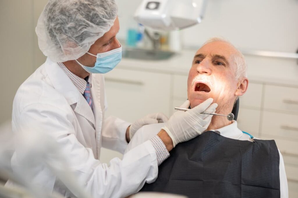 A dentist inspects an upper jaw bone augmentation procedure
